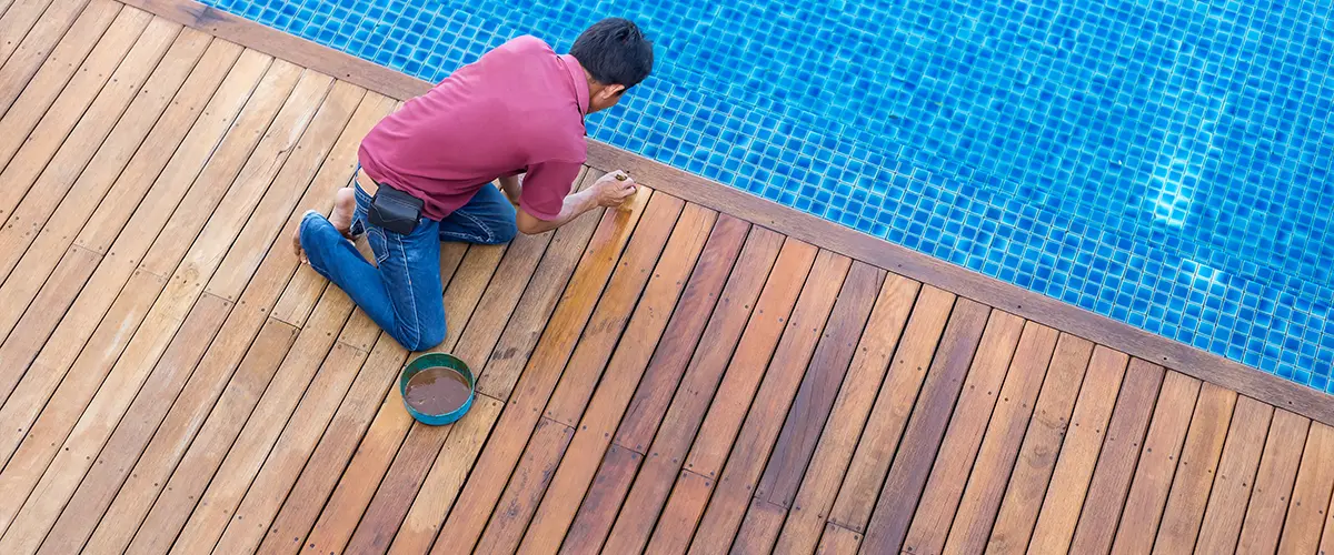 A man sealing a wood deck