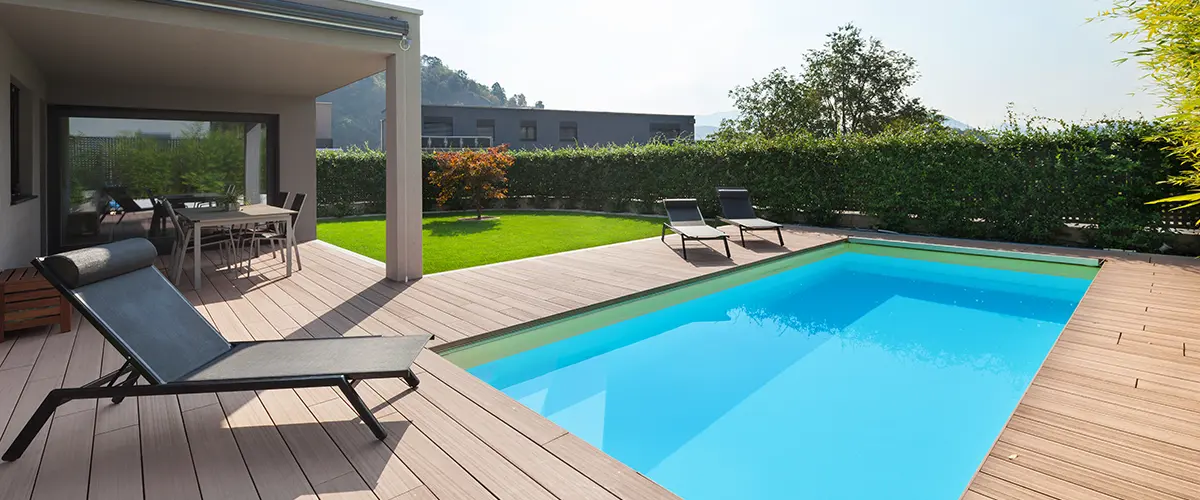 Composite decking around a pool with long chairs