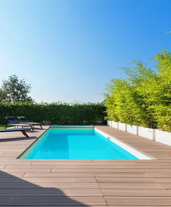 Composite decking around a pool and two long chairs