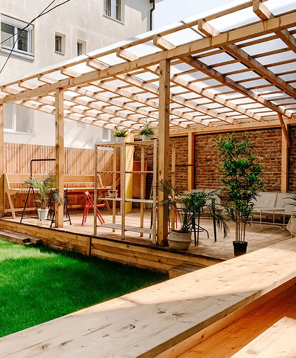 Wood decking with a plant and a patch of grass