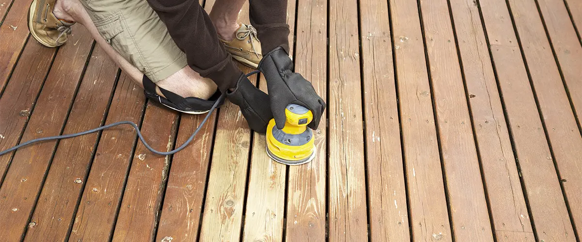 The best deck repair companies in Omaha working on sanding a wooden deck