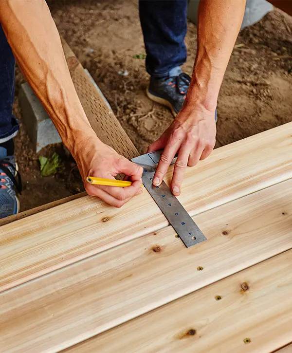 A deck builder repairing a wood deck