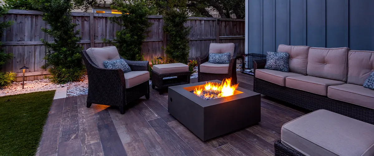 A deck with a fireplace and outdoor furniture