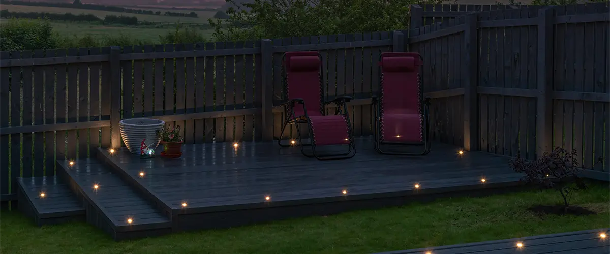 A freestanding deck at night with lights on