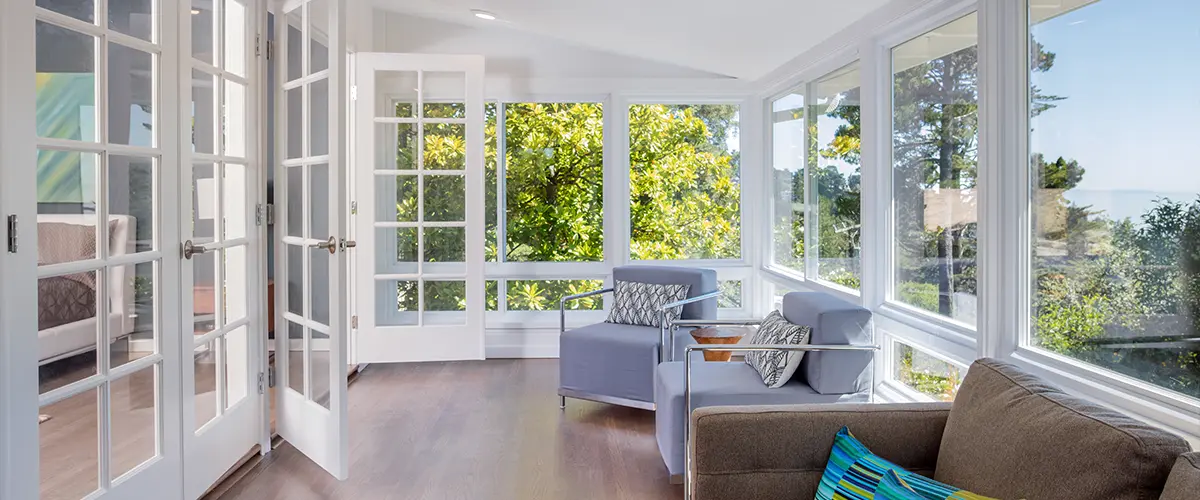 A sunroom with wood flooring and furniture