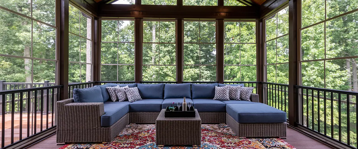 A sunroom with outdoor furniture and wood features