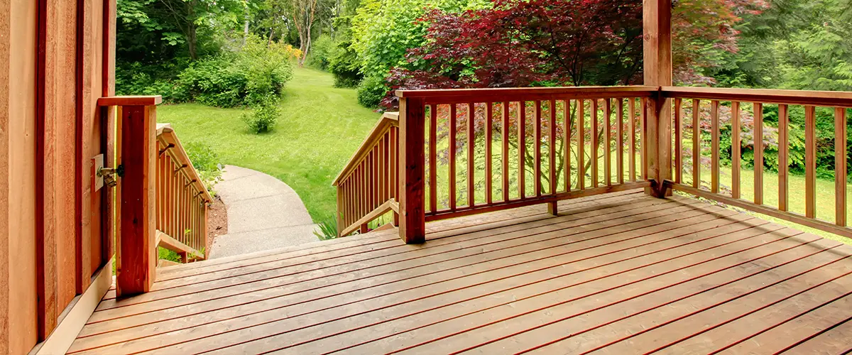 A wood deck with railing and a set of stairs