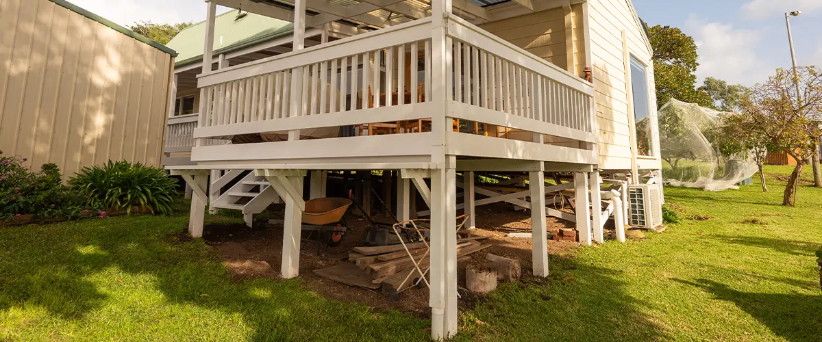 Dry space under deck with railing and posts painted white