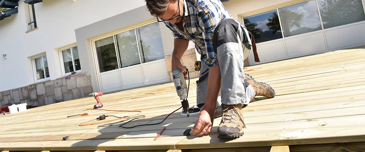 A man from one of the best deck repair companies in Gretna fixing a deck