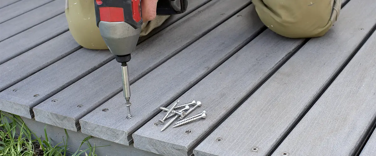 A contractor using screws on a PVC deck