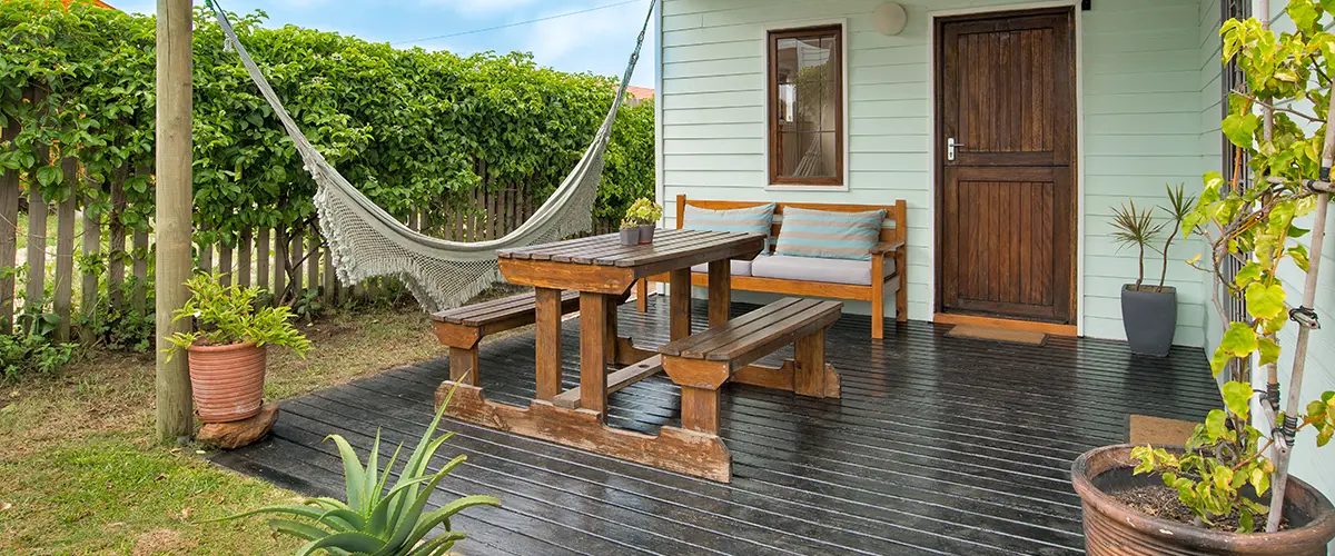 A wet deck on a patio with a wood table