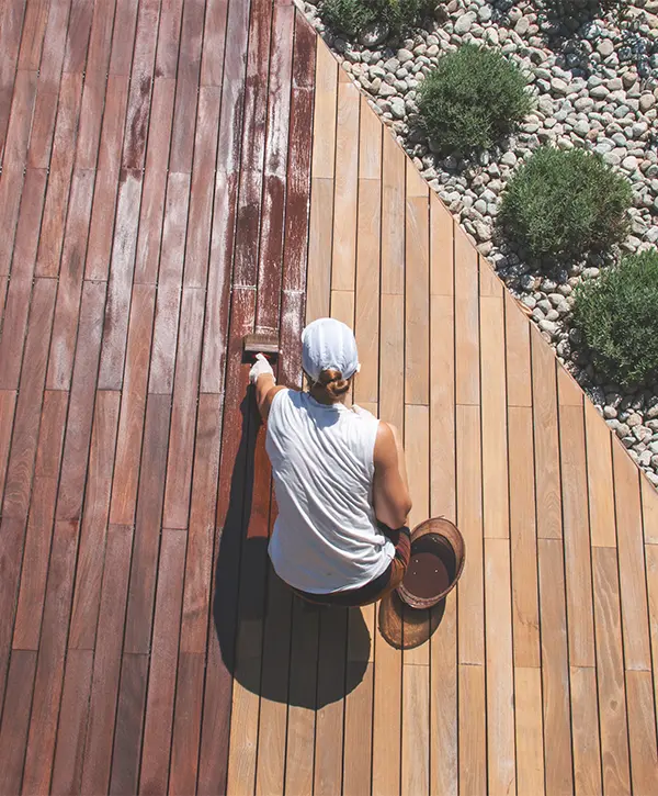 Woman staining a wood deck