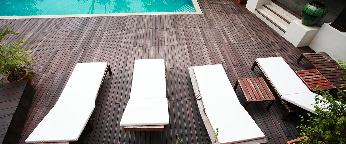 Wood decking with long chairs around a pool made by one of the best deck repair companies in Fremont, NE