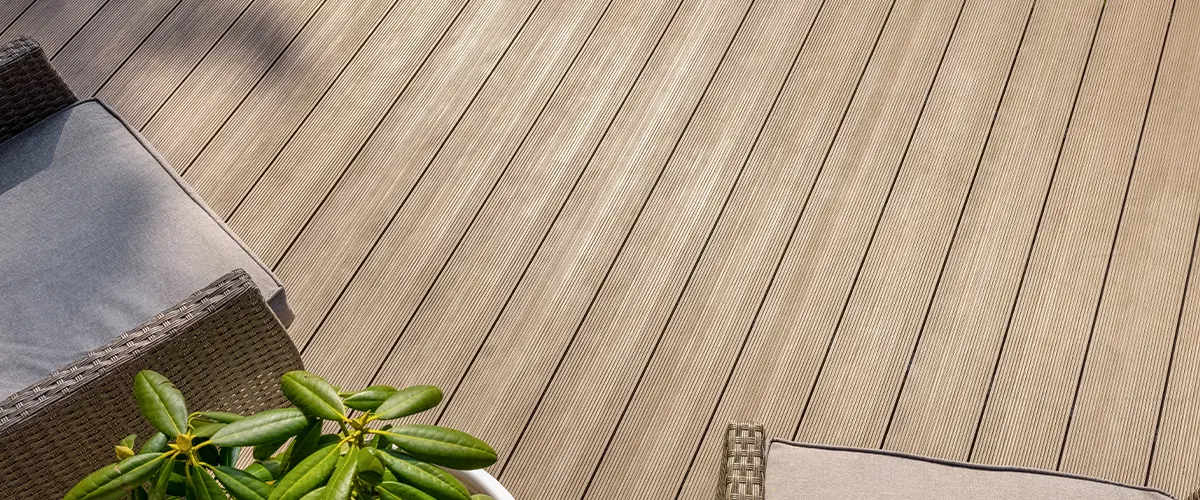 Beige composite decking with a plant and two chairs