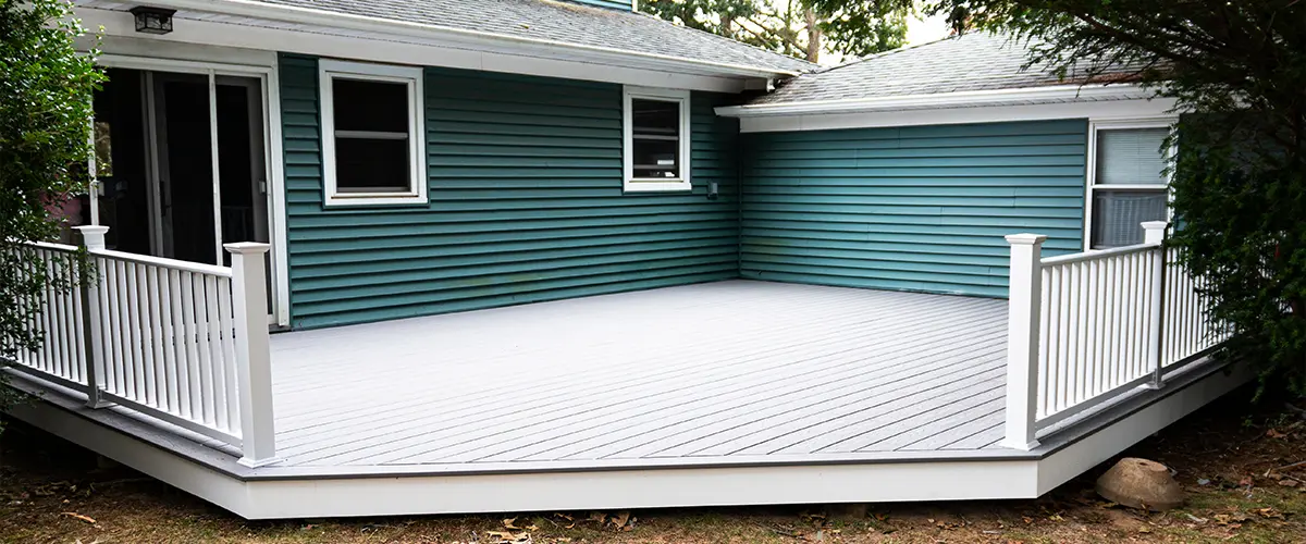 Composite decking on a home with blue siding and white metal rails