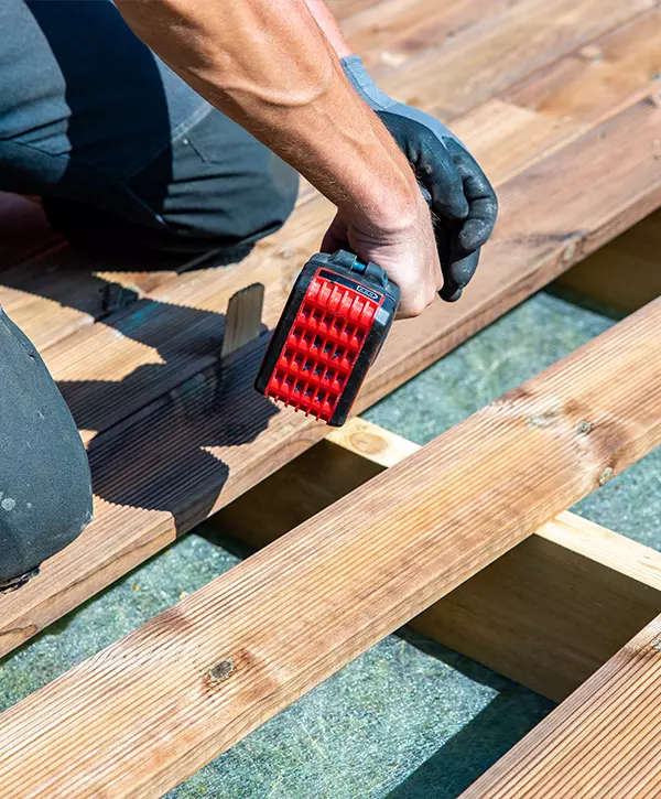 builder hand with electric screwdriver installing impregnated wooden boards, Deck Installation In Council Bluffs, IA