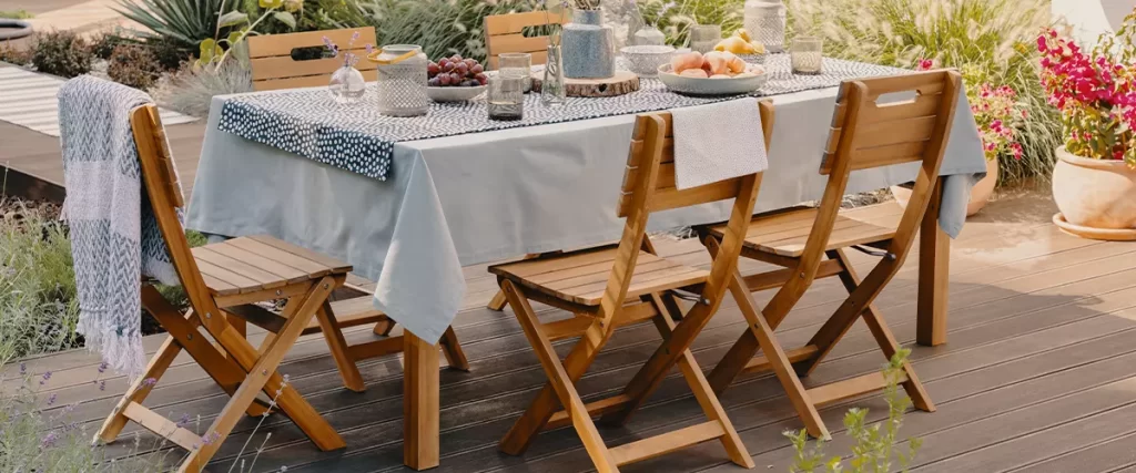 photo of a dining table with wooden chairs set on the terrace