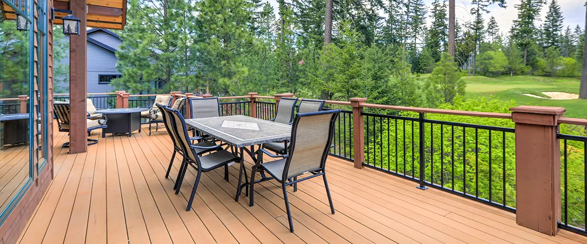 Beautiful large cabin home with large wooden deck and chairs with table overlooking golf course