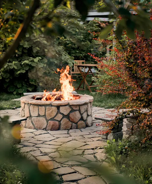 firepit with fire burning in a green garden