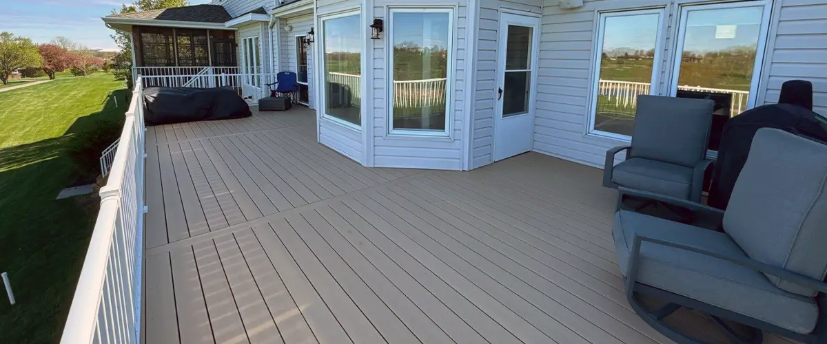 Spacious modern deck installation at two-story home with lounge chairs and gazebo.