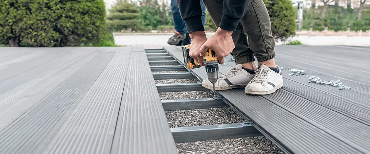 Composite deck repair in Plattsmouth, using a drill, showcasing close-up of decking process and tools on a construction site