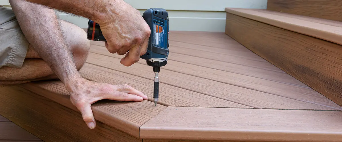 TimberTech vs. Trex: learn about installation techniques and materials. Featured: a professional fitting composite deck stairs with a drill.