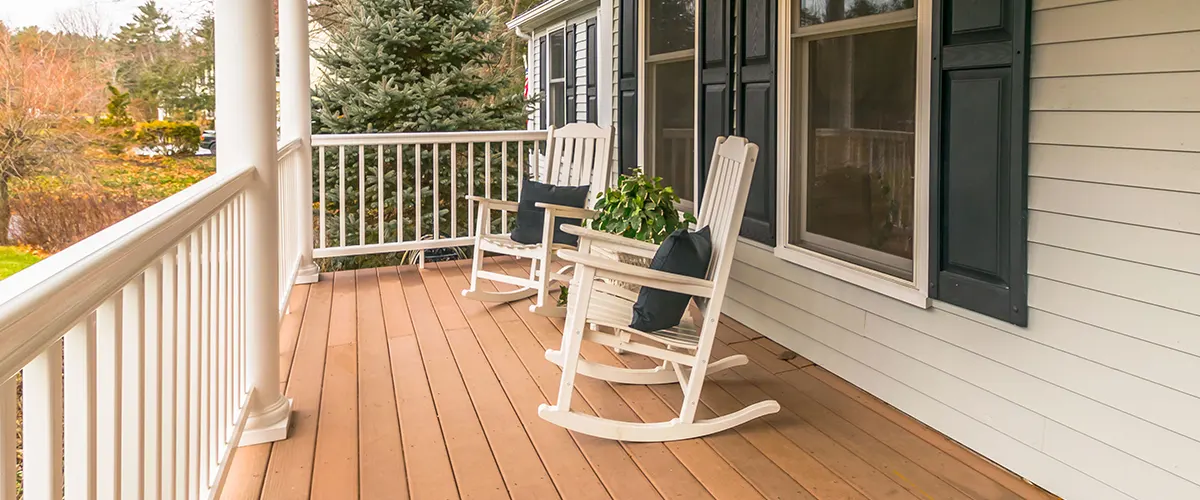 Explore common Trex decking issues and how to resolve them. This image features a charming porch with classic white railings and comfortable rocking chairs.