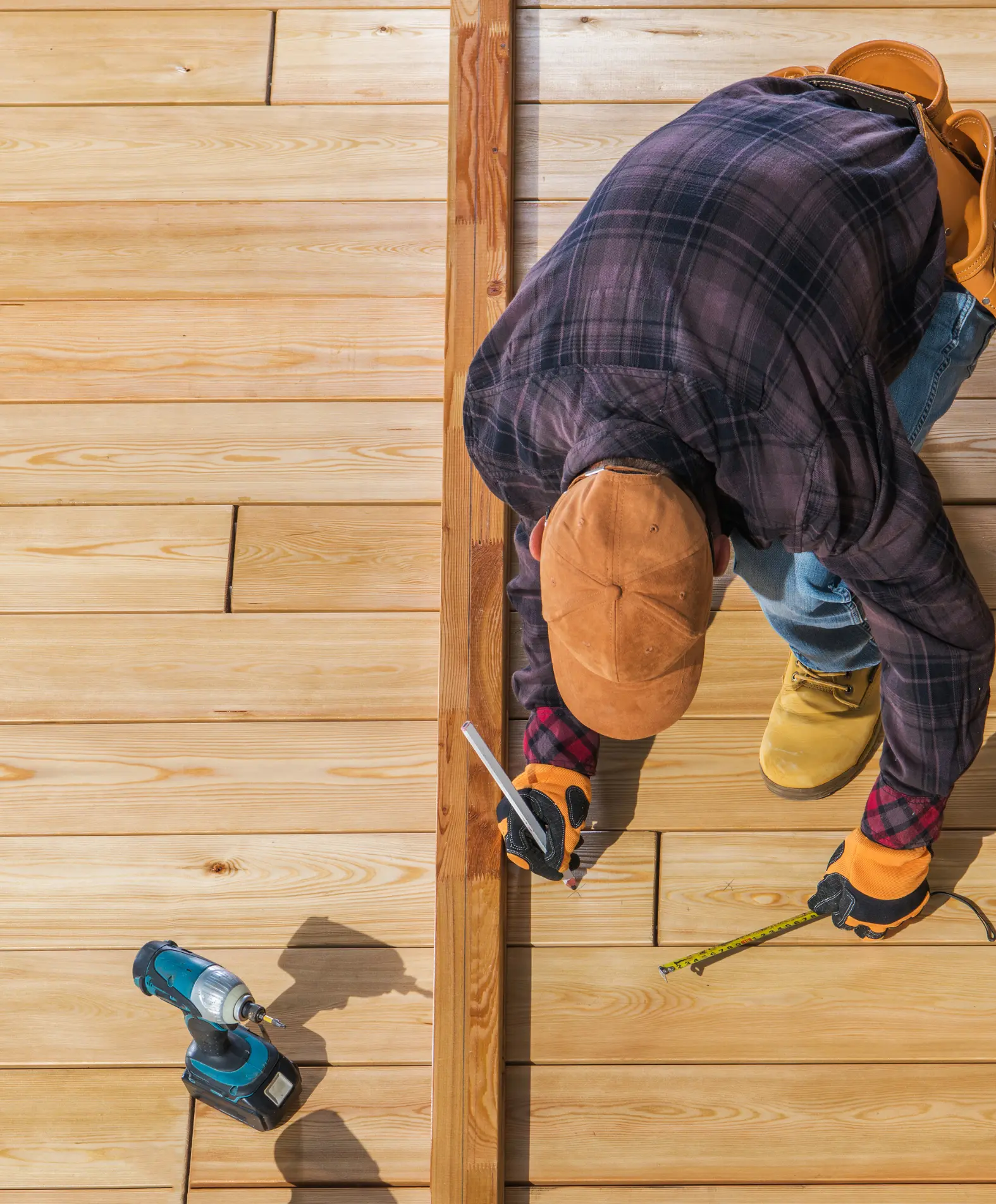 Close-up of construction worker building a wooden deck with tools