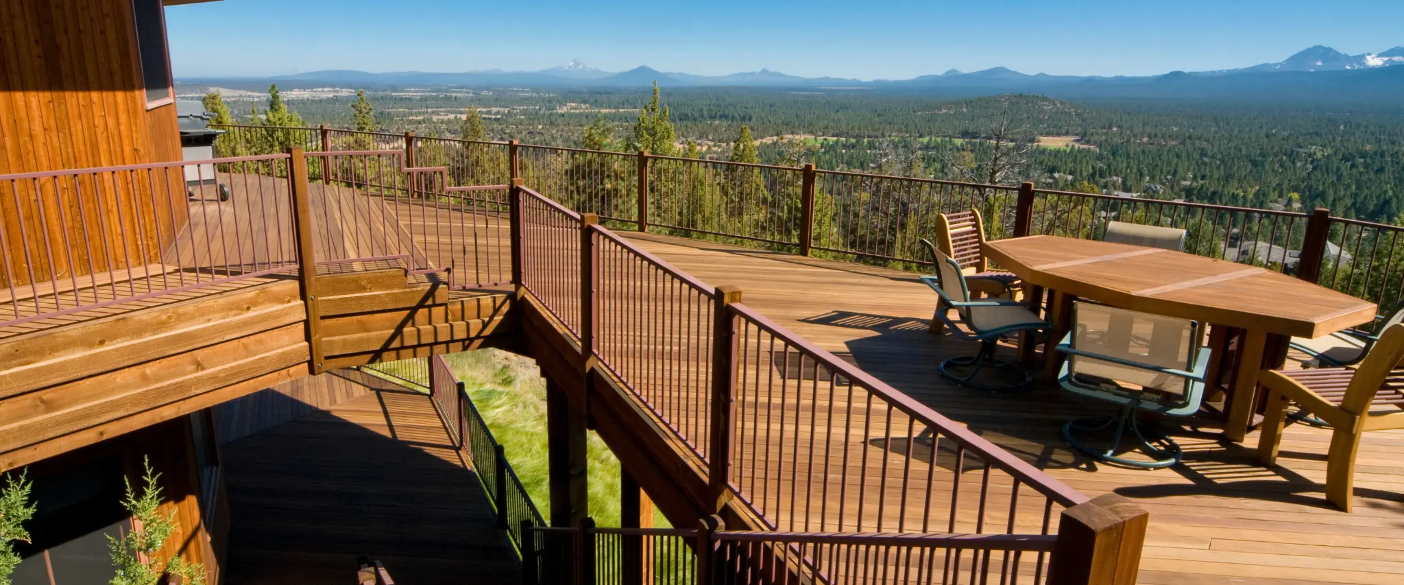 Spacious deck with wooden railings offering stunning views of the surrounding landscape