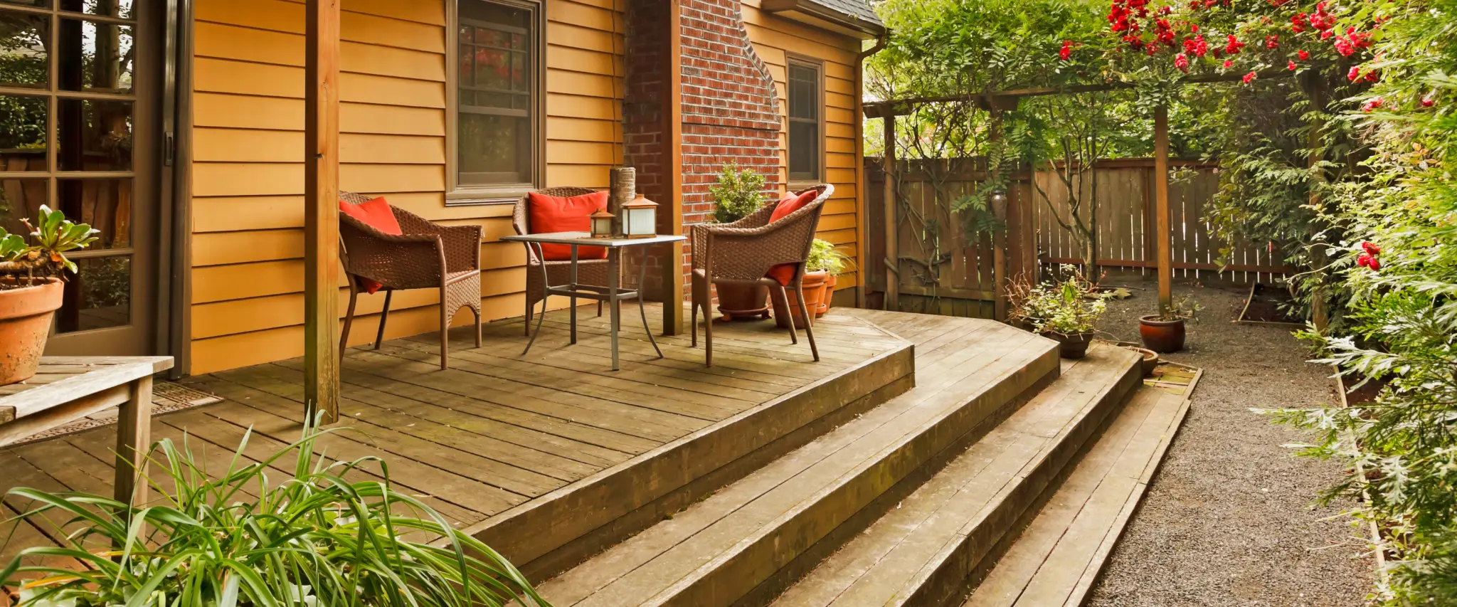 Stepped wooden deck leading to a garden area with plants and flowers