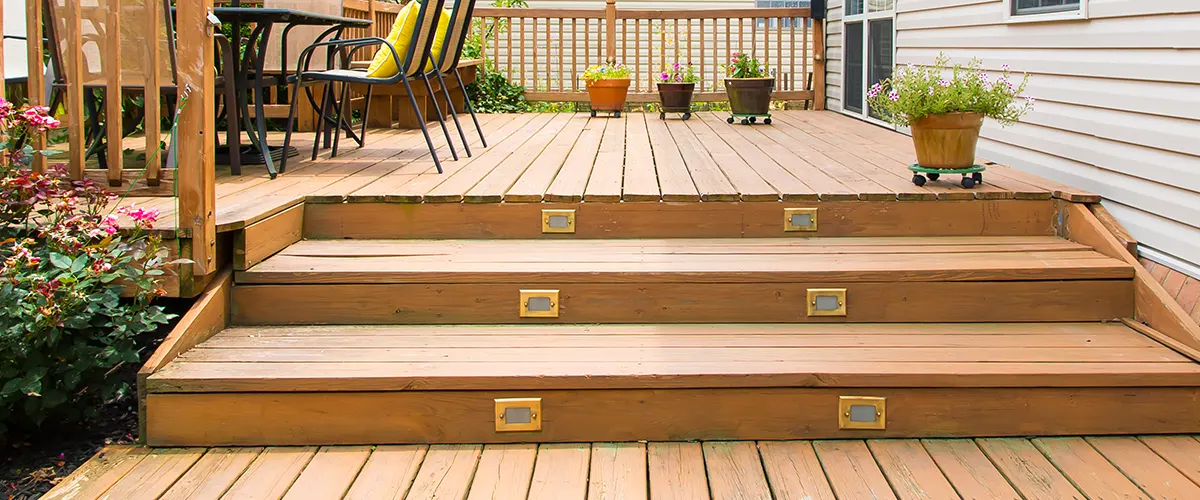 Discover common Trex decking issues and expert fixes. This image showcases a wooden deck with illuminated steps, seating areas, and vibrant plants.