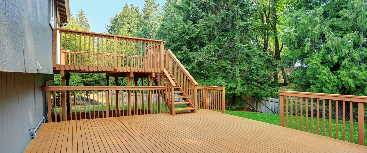 Spacious multi-tiered wooden backyard deck with multiple levels and staircases attached to a modern home, perfect for outdoor living.