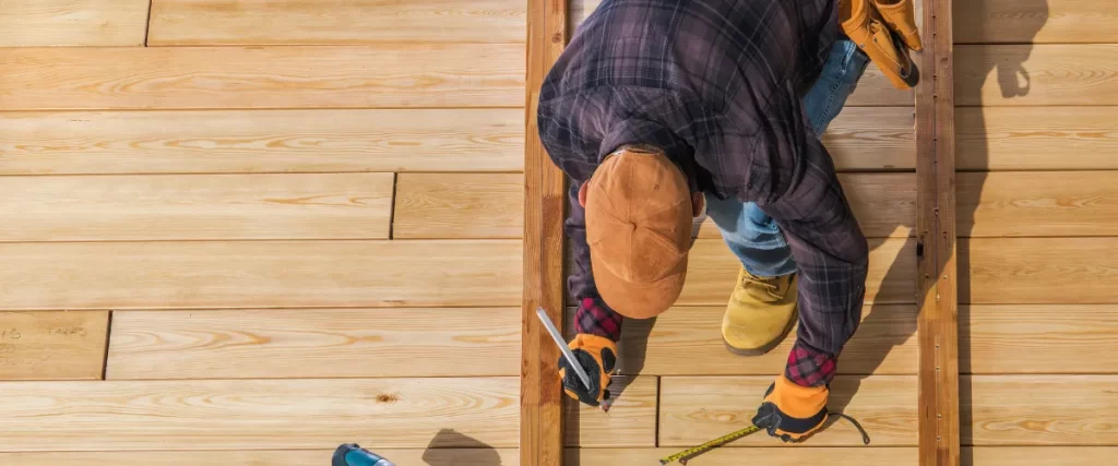 Close-up of a contractor aligning and securing wooden decking boards