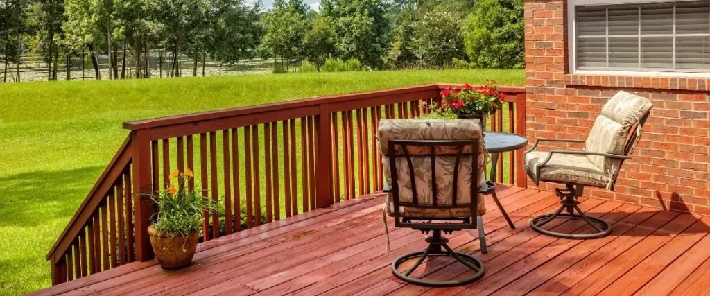 red stained wooden deck with patio chairs