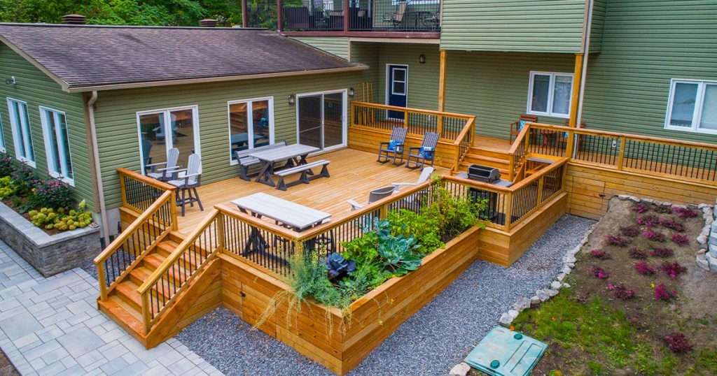Storage Solutions Under Your Deck Custom multi-level wood deck with built-in seating, raised garden bed, and outdoor dining area in a spacious backyard