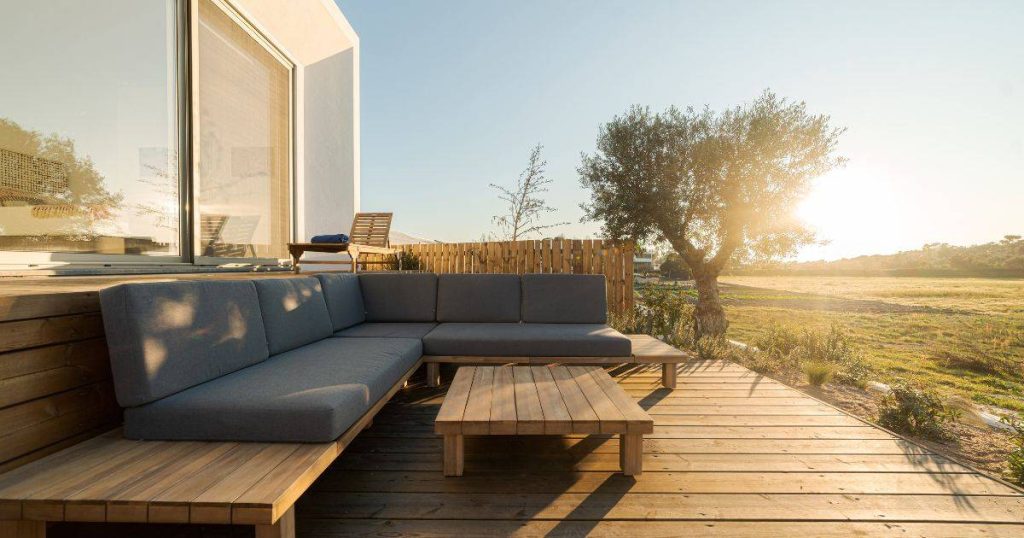 Another view of the same outdoor sectional sofa and coffee table on a deck, from a slightly different angle.