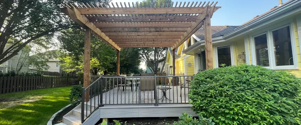 How Wind Load Affects Elevated Decks in Tornado-Prone Areas Backyard composite deck with pergola and metal railing for shaded outdoor seating area