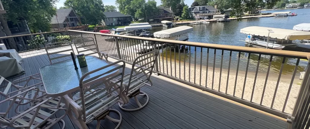 How Wind Load Affects Elevated Decks in Tornado-Prone Areas Composite deck with glass table overlooking lakeside dock and waterfront views