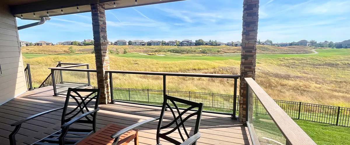 Covered Deck Builder in Lincoln, NE Covered second story deck with glass railing and panoramic golf course view from composite decking surface