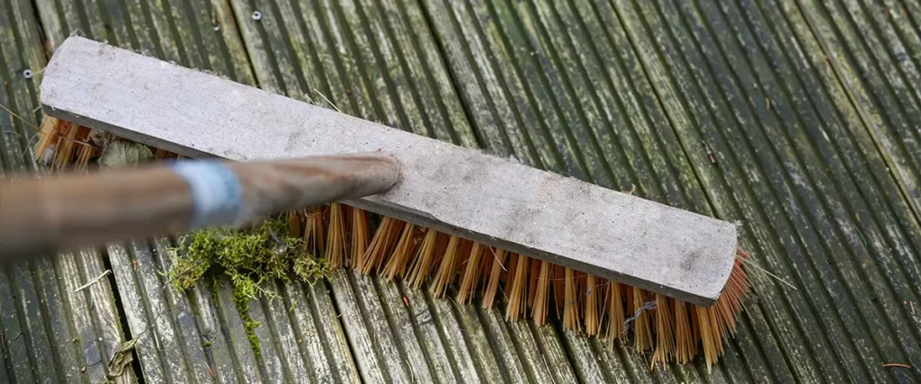 How to Deal With Algae Growth on Shady Decks Scrubbing moss from weathered wood decking during deck maintenance and cleaning