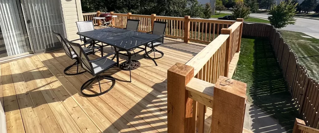 How Wind Load Affects Elevated Decks in Tornado-Prone Areas Spacious backyard wood deck with dining set and railing, perfect for outdoor entertaining