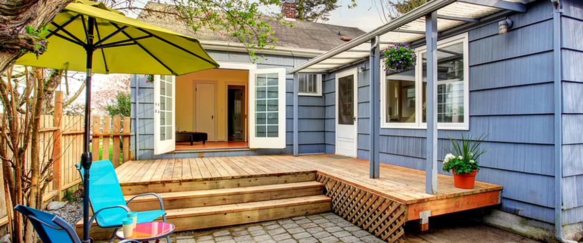 covered deck installation lincoln ne deck building blue house with a professional grade wooden deck patio furniture and pergola