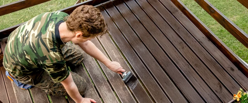 Deck Maintenance in Lincoln: Protecting Your Deck from Sun and Humidity deck maintenance lincoln ne a skilled contractor staining a wooden deck with professional precision
