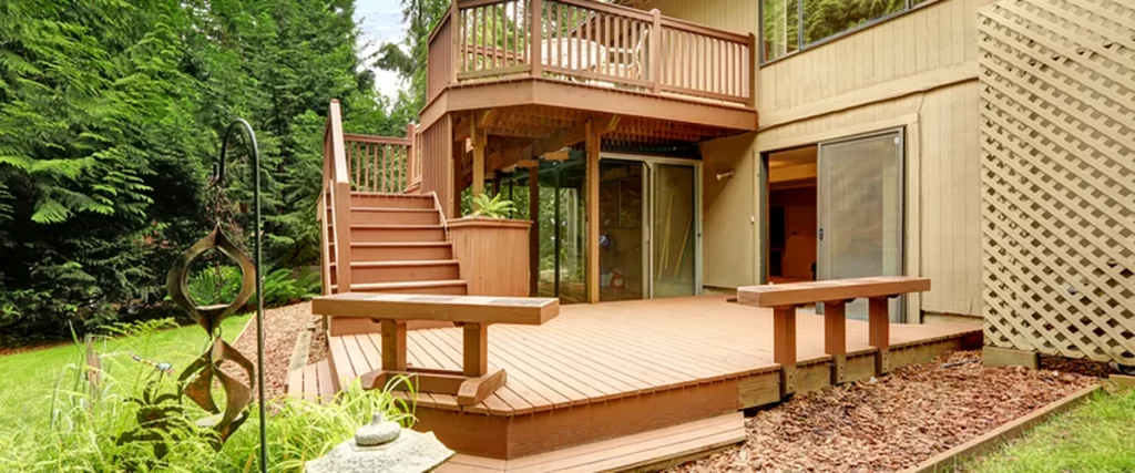 Deck Maintenance in Lincoln: Protecting Your Deck from Sun and Humidity deck maintenance lincoln ne two level wooden deck with railing surrounded by landscaped garden and trees
