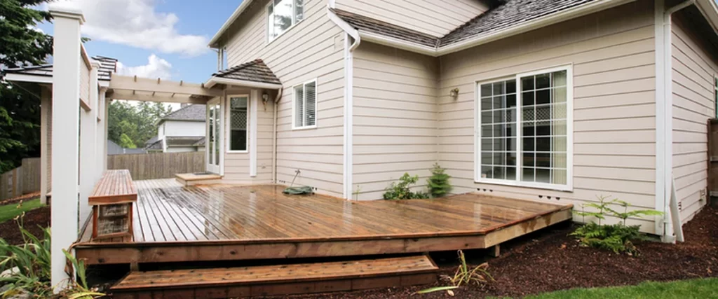lincoln ne professional contractor built wooden deck with pergola beige siding and lush lawn