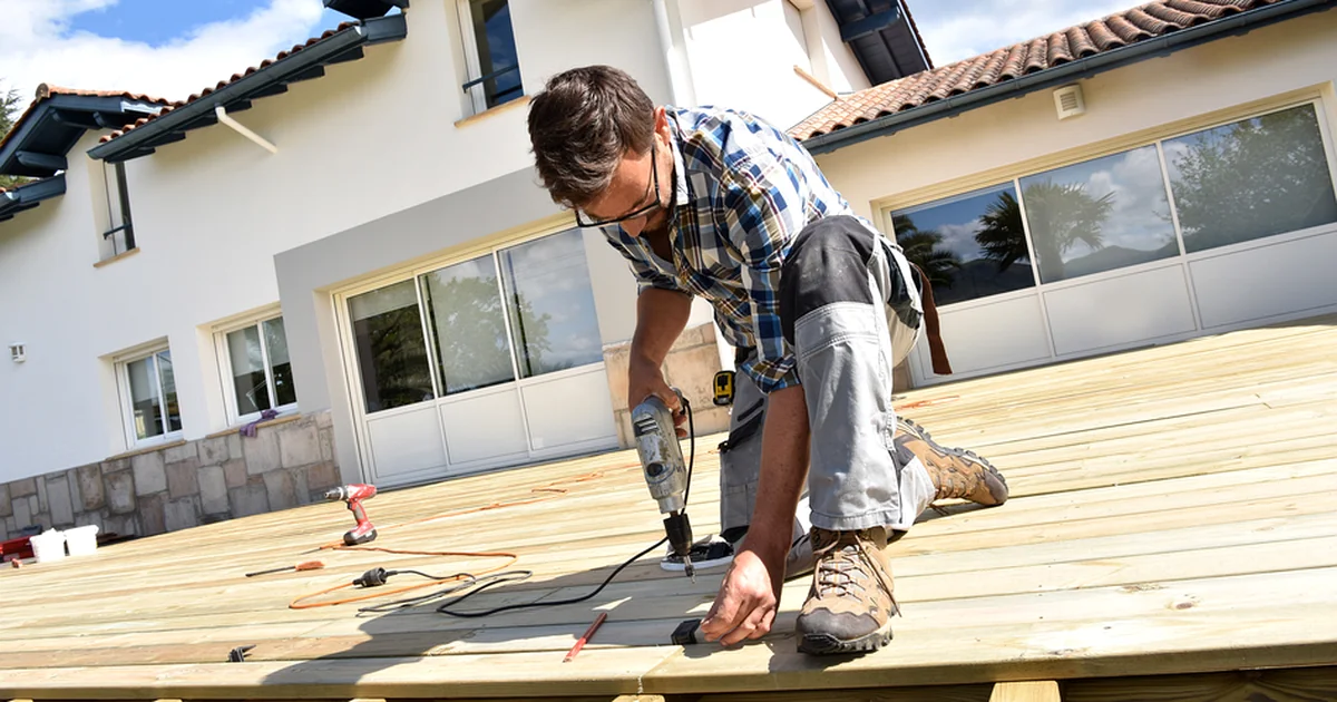 Blog lincoln ne professional contractor installing a wooden deck with power drill outdoors