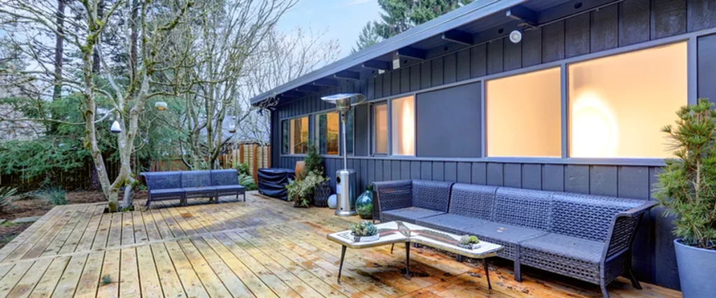 Lincoln Homeowners’ Guide to Preparing Your Deck for Winter lincoln ne spacious wooden deck with modern dark siding wicker seating and patio heater