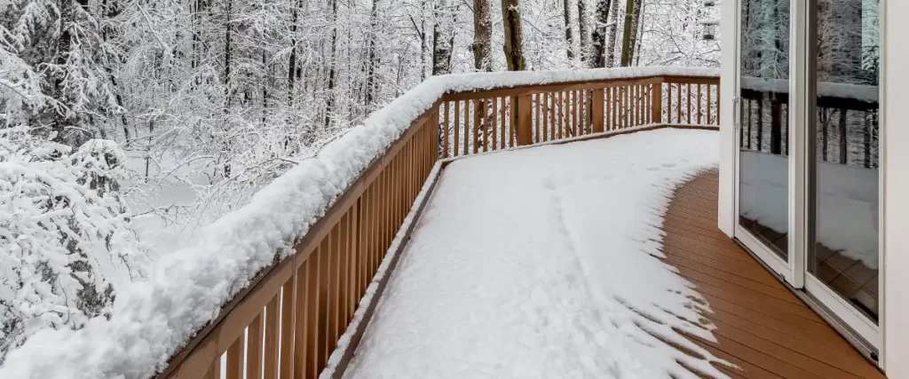 a large composite deck on a luxury home in a snowy, winter setting