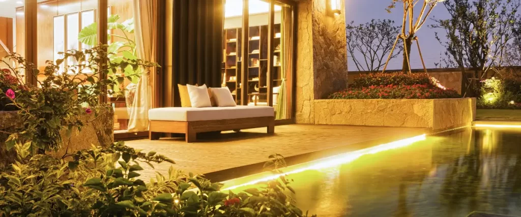 a modern, luxurious deck by the pool with ambient lighting