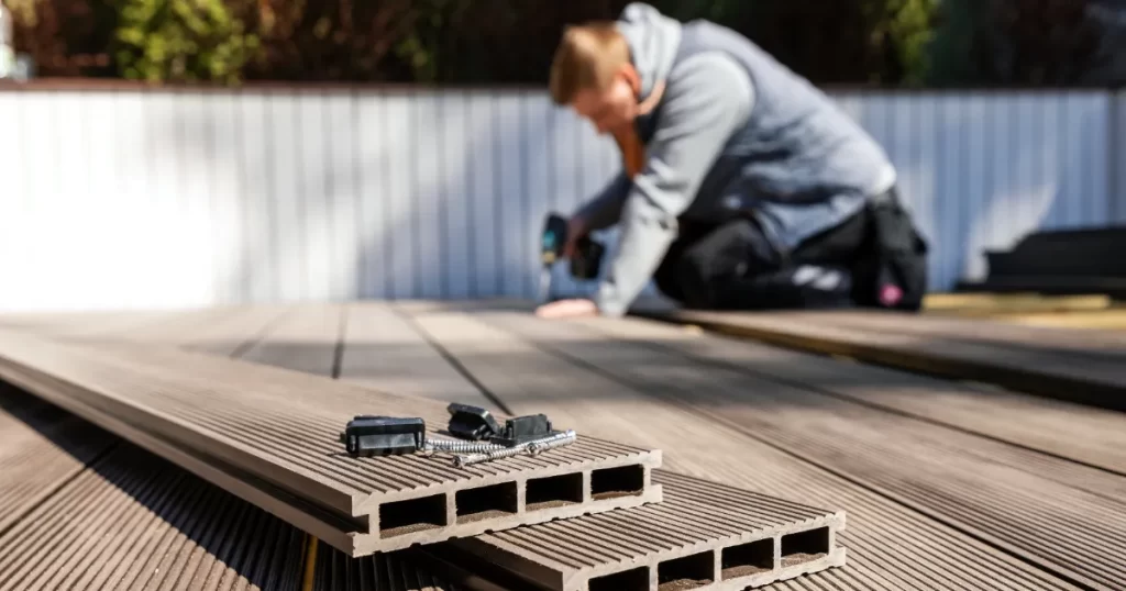 a person installing composite decking, a durable and low-maintenance alternative to traditional wood decking